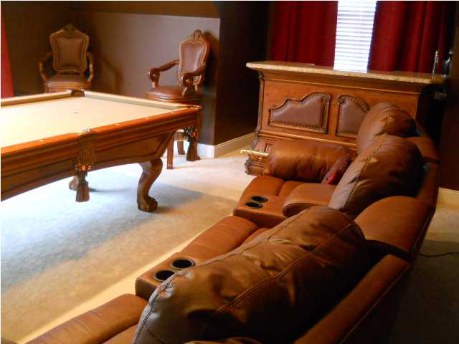 The pool table, wet bar, and two sets of 'power reclining' theater sofas come with the house along with a projector and large screen.