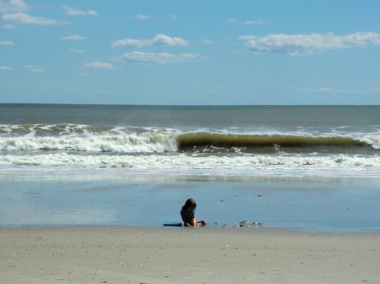 The waves are sneaking up on her, getting closer